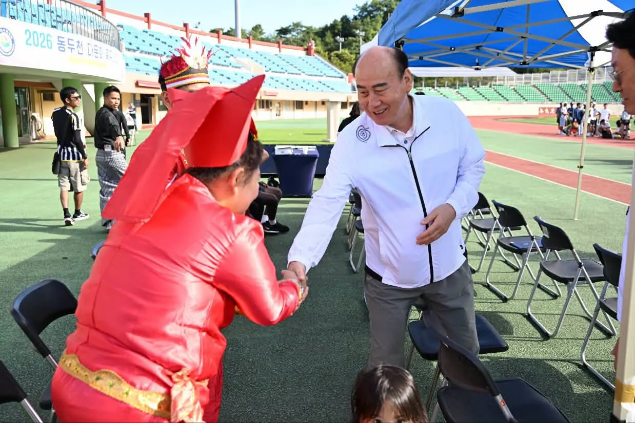 Mayor 박형덕 greeting a participant before kick-off. He wrote afterwards that “언어는 달라도, 축구를 향한 열정은 같았습니다” — the languages differ, the appetite for football does not. Photograph by 박형덕, Mayor of Dongducheon.