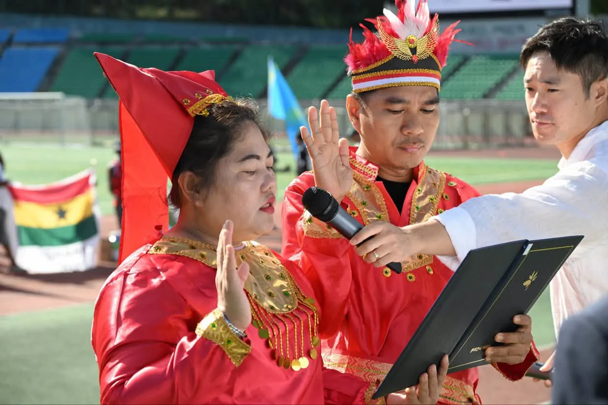 Two team representatives take the players' oath in traditional dress, the flags of Ghana and Kazakhstan behind them. Fourteen countries were represented across eighteen teams. Photograph by 박형덕, Mayor of Dongducheon.